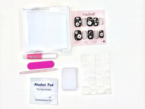 Nailoli Signature set with nail glue, a sheet of adhesive tabs, nail file, buffing block, cuticle pusher, alcohol pad, and case