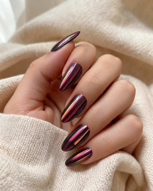 Hand with metallic pink and purple nail polish on a beige fabric background