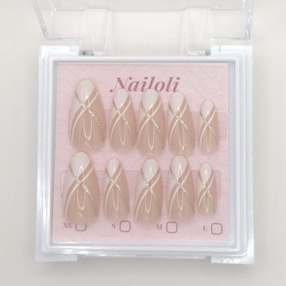 Set of press-on nails with gold accents in a 'Nailoli' box on a light background
