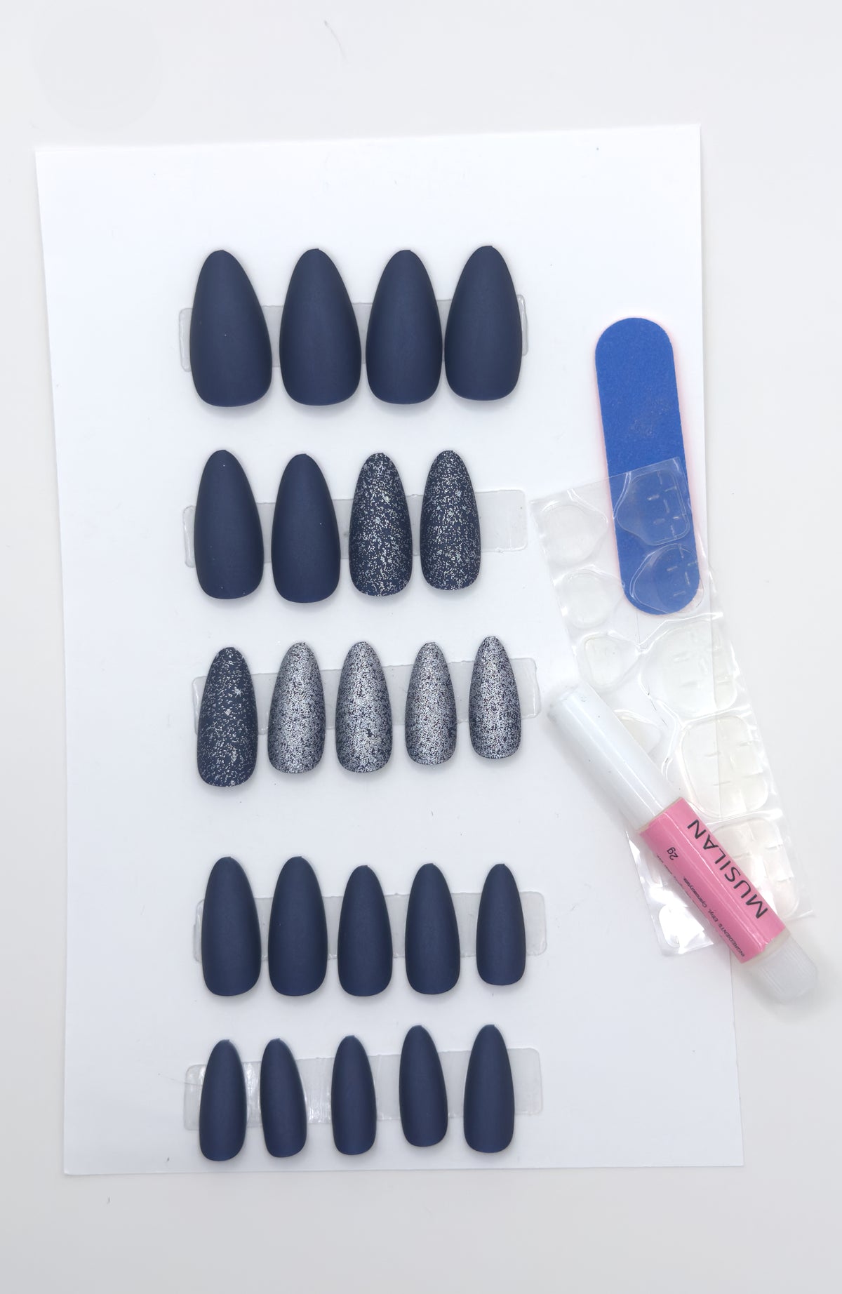 Full midnight navy set beside a nail file and adhesive tabs