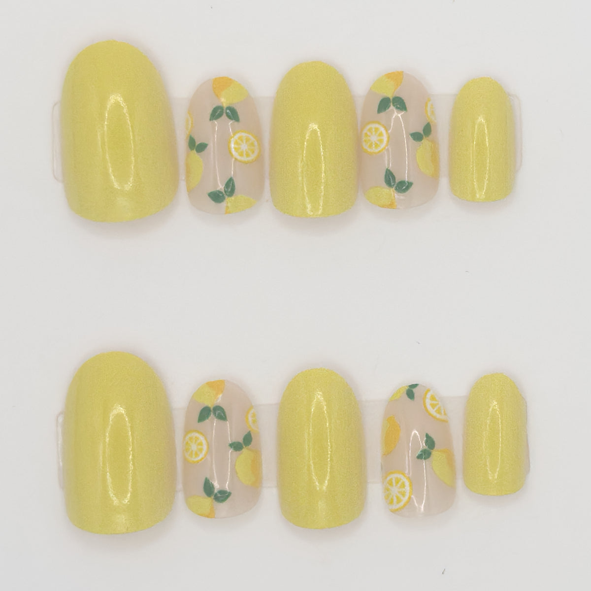 Set of yellow nail wraps with lemon designs on a white background