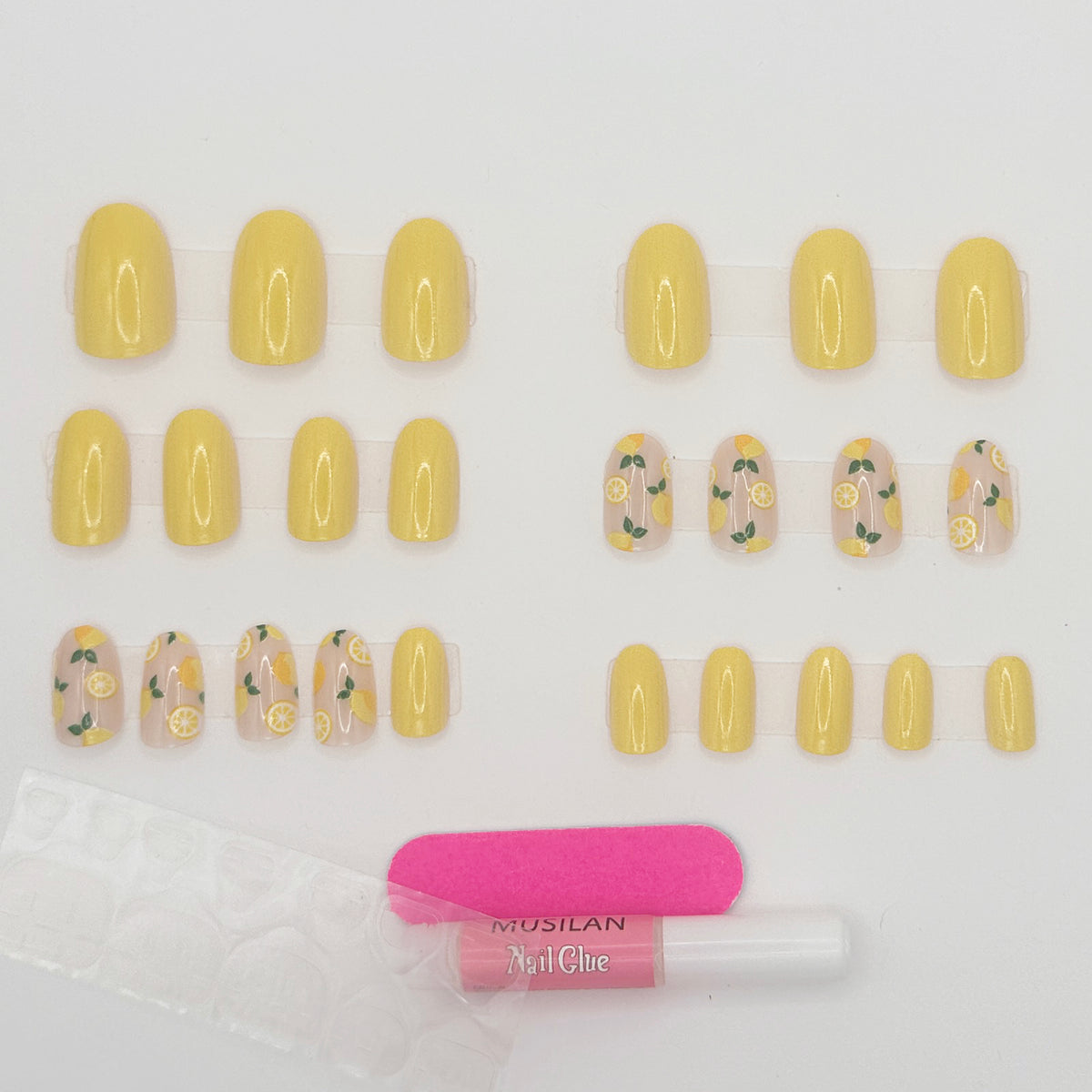 Set of yellow nail extensions with floral designs and a bottle of nail glue on a white background