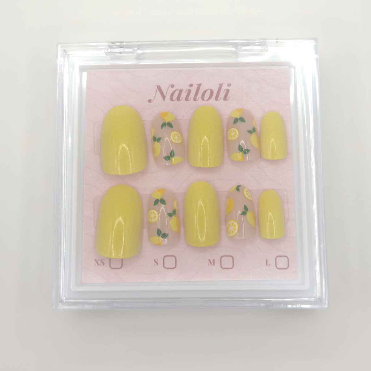 Lemon slice nails on the pink Nailoli backing card inside the closed clear case