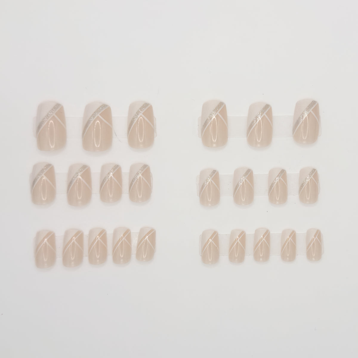 Set of beige nail wraps with a decorative pattern on a light gray background