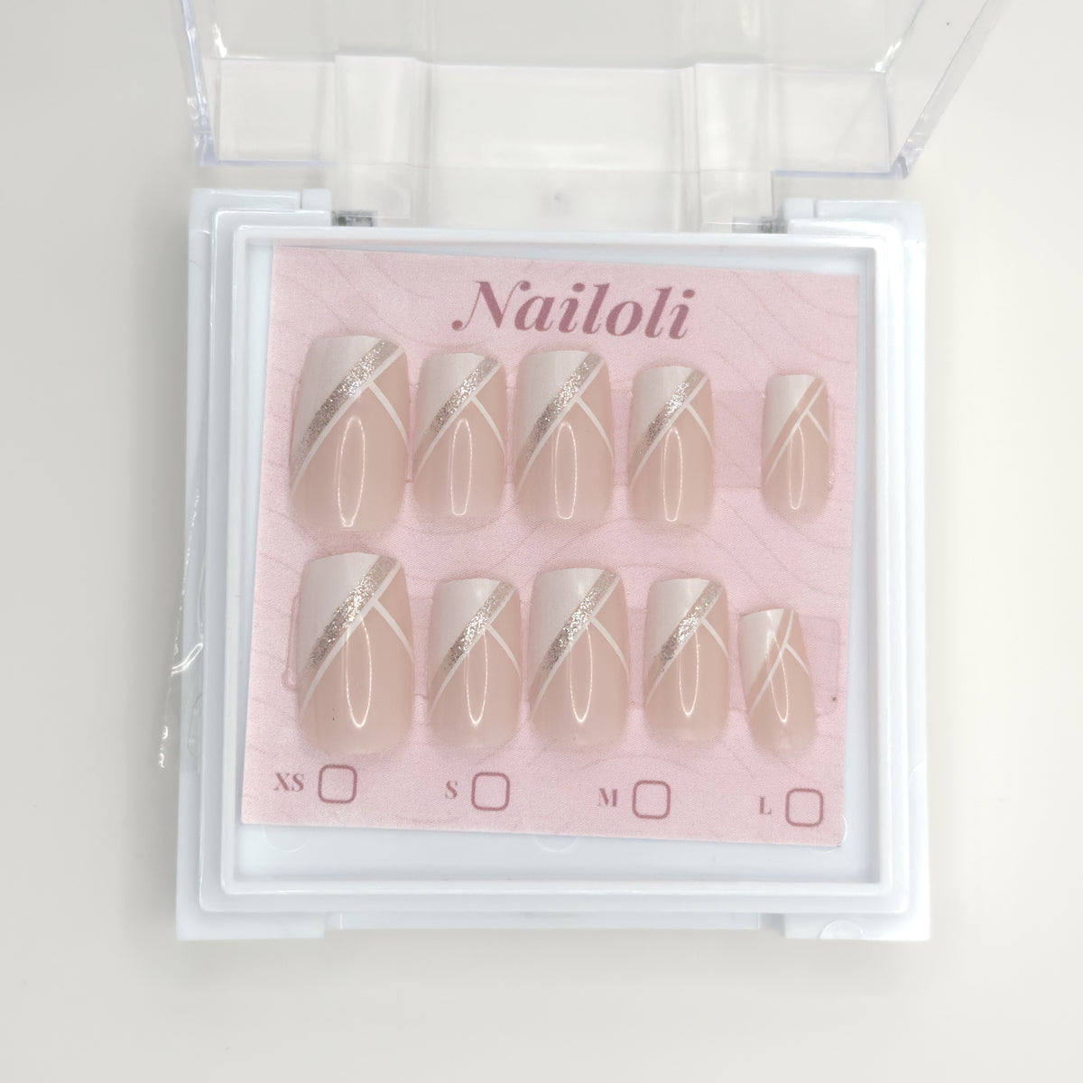 Nailoli nail art set with beige and gold designs in a clear plastic case.