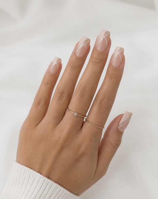 Hand wearing a delicate gold ring with a small diamond on a plain background