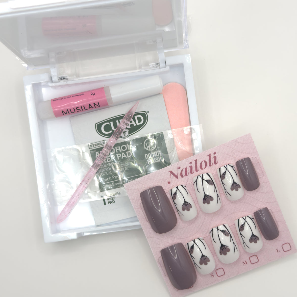 Taupe floral set on its card beside the open kit with glue, prep pad, file, and cuticle stick