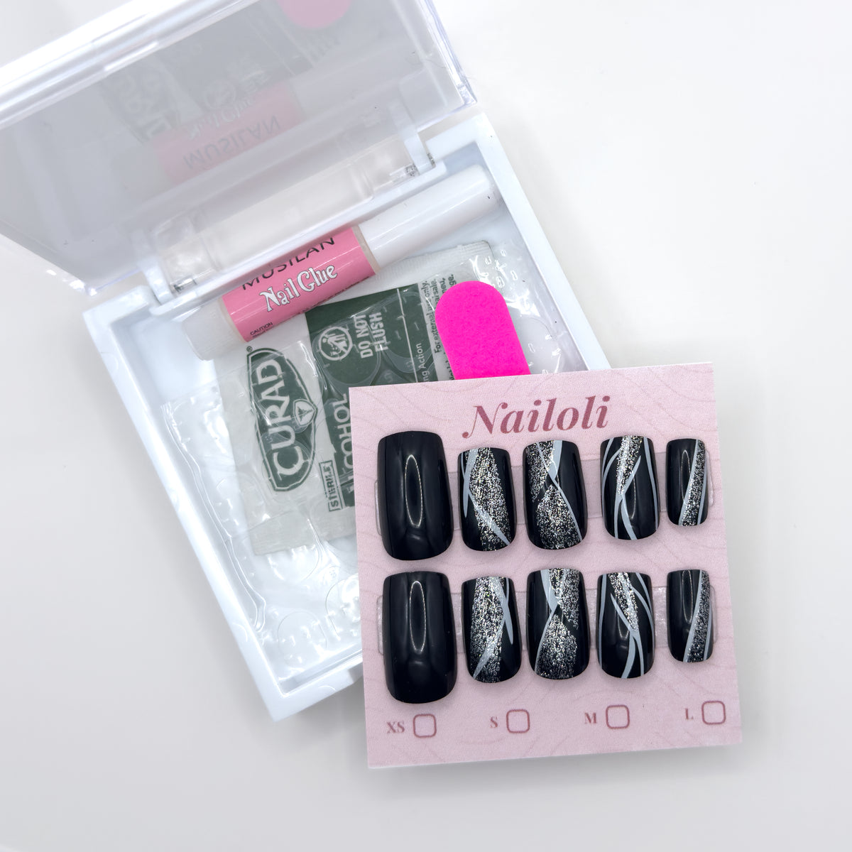 Glossy black set on its card beside the open kit with glue, prep pad, adhesive tabs, and nail file