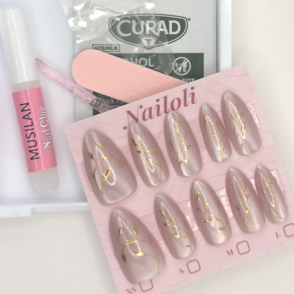 Lilac pearl set on its card beside nail glue, a cuticle stick, nail file, and prep pad