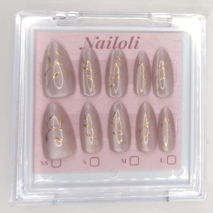 Set of nail extensions with gold leaf design in a 'Nailoli' branded box.