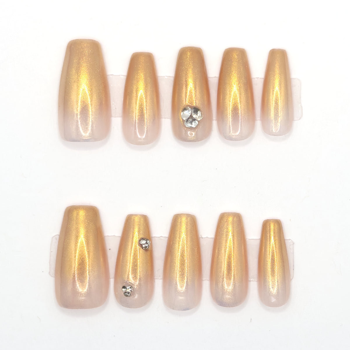10 gold chrome coffin press-ons in two rows, fading to nude, with heart and single gemstones
