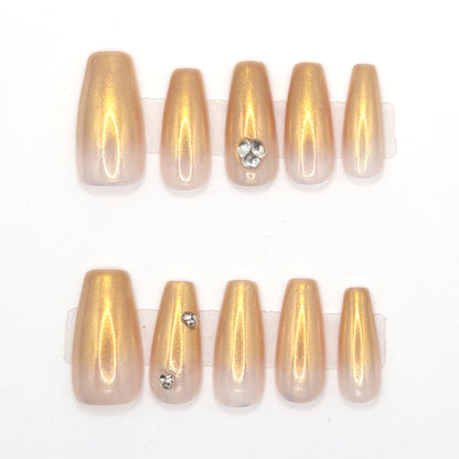 10 gold chrome coffin press-ons in two rows, fading to nude, with heart and single gemstones