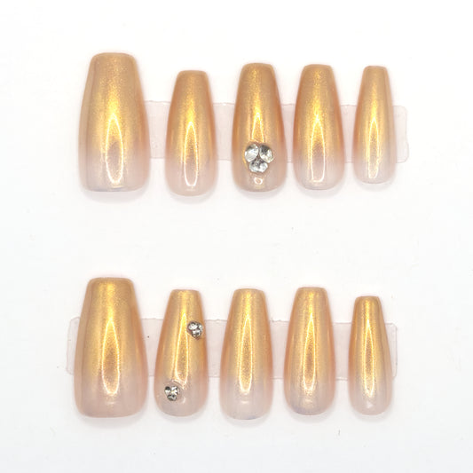 10 gold chrome coffin press-ons in two rows, fading to nude, with heart and single gemstones