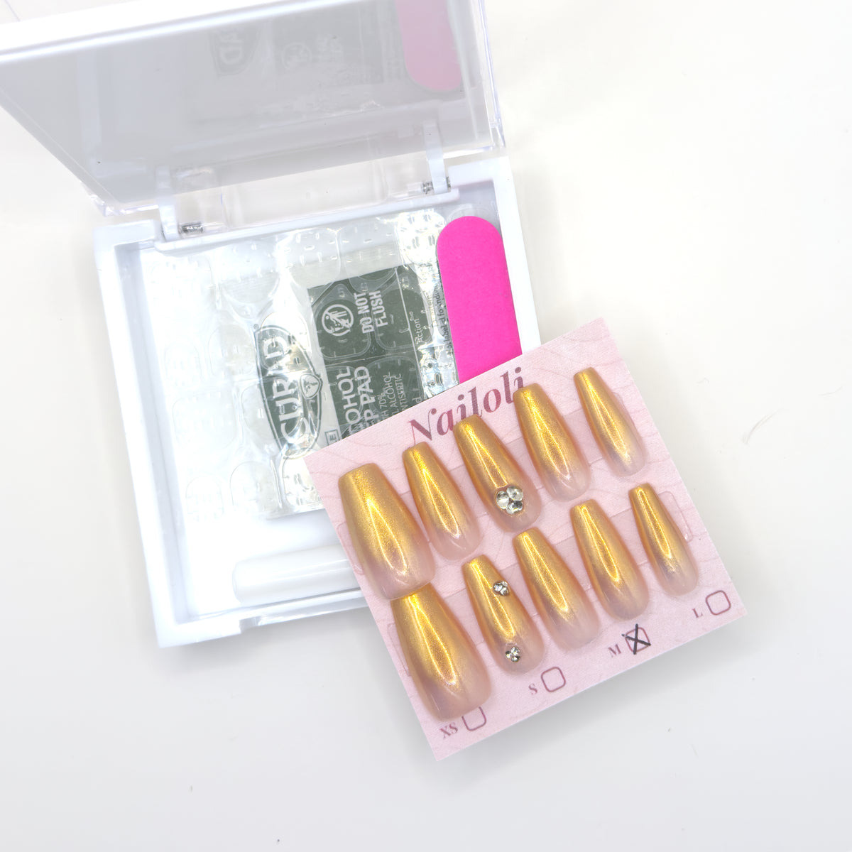Champagne gold set on its backing card beside the open kit with alcohol prep pad and nail file