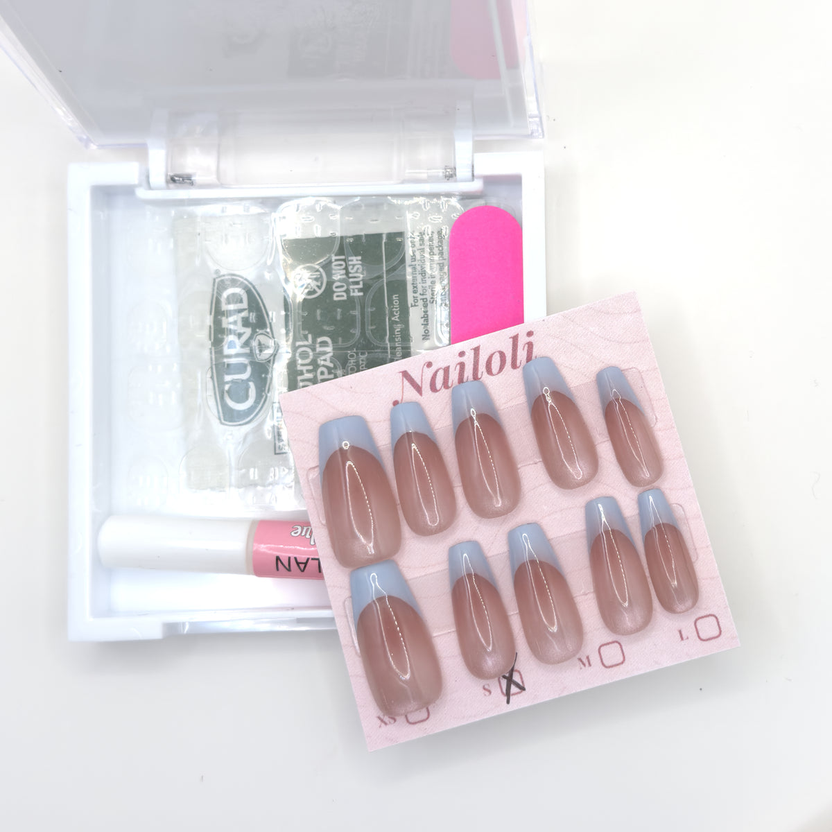 Powder blue French set on its card beside the open kit with alcohol prep pad and nail file