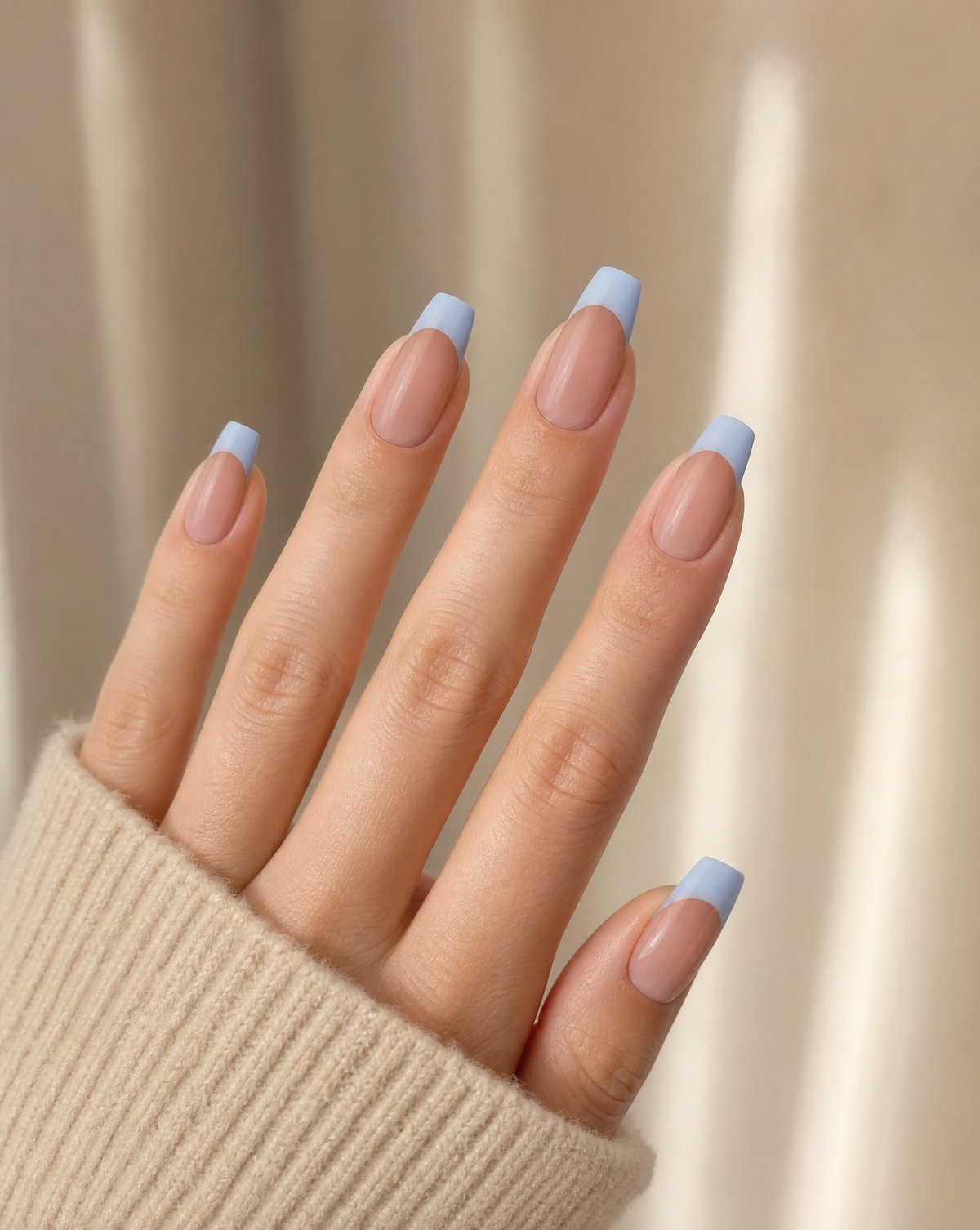 Hand wearing sheer blush coffin press-ons with powder blue French tips