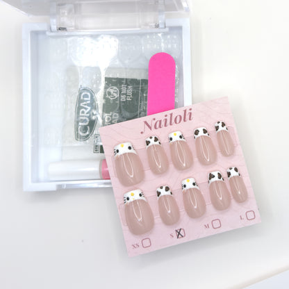 Cat and cowprint set on its backing card beside the open kit with alcohol prep pad and nail file