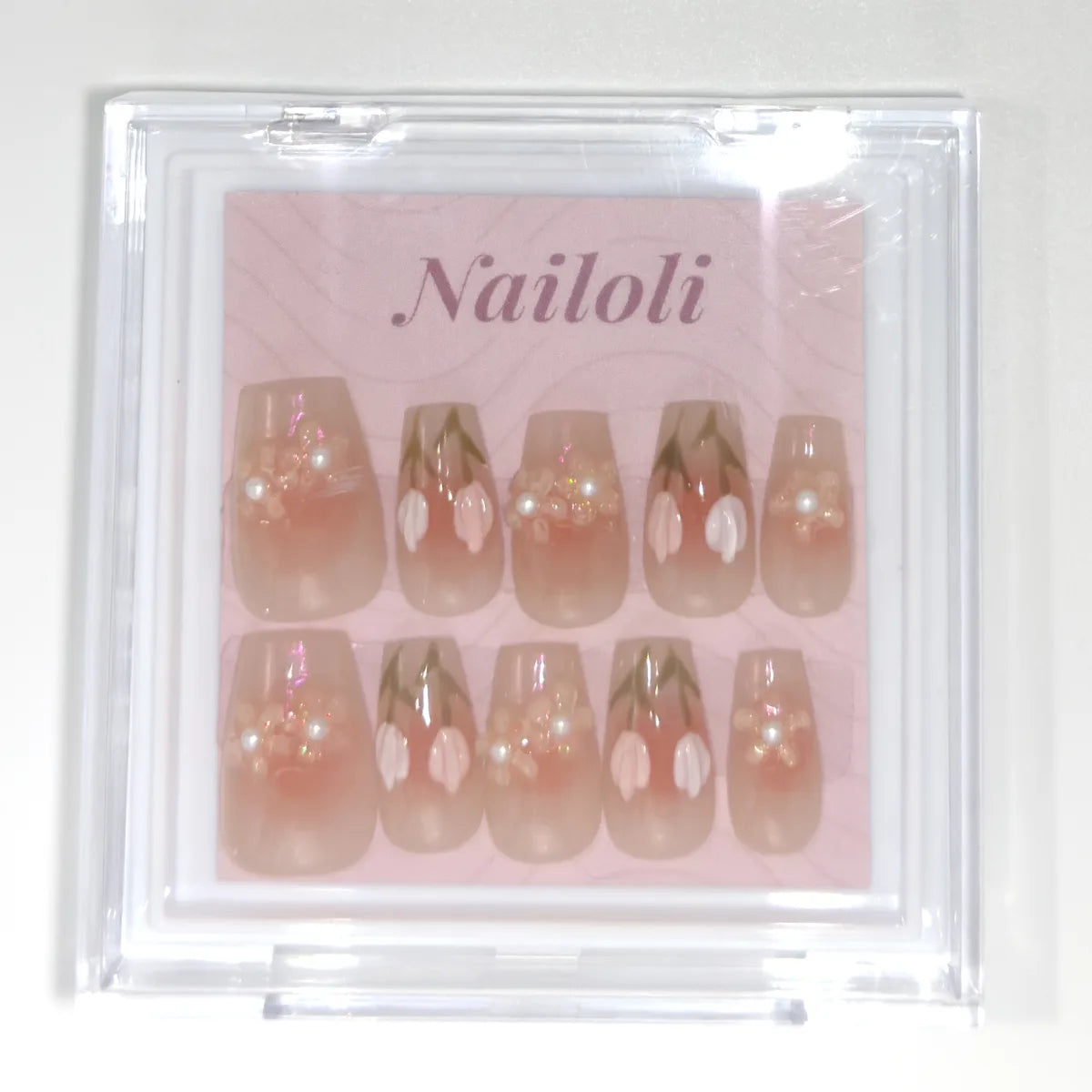 Closed clear Nailoli case holding the sheer peach coffin set