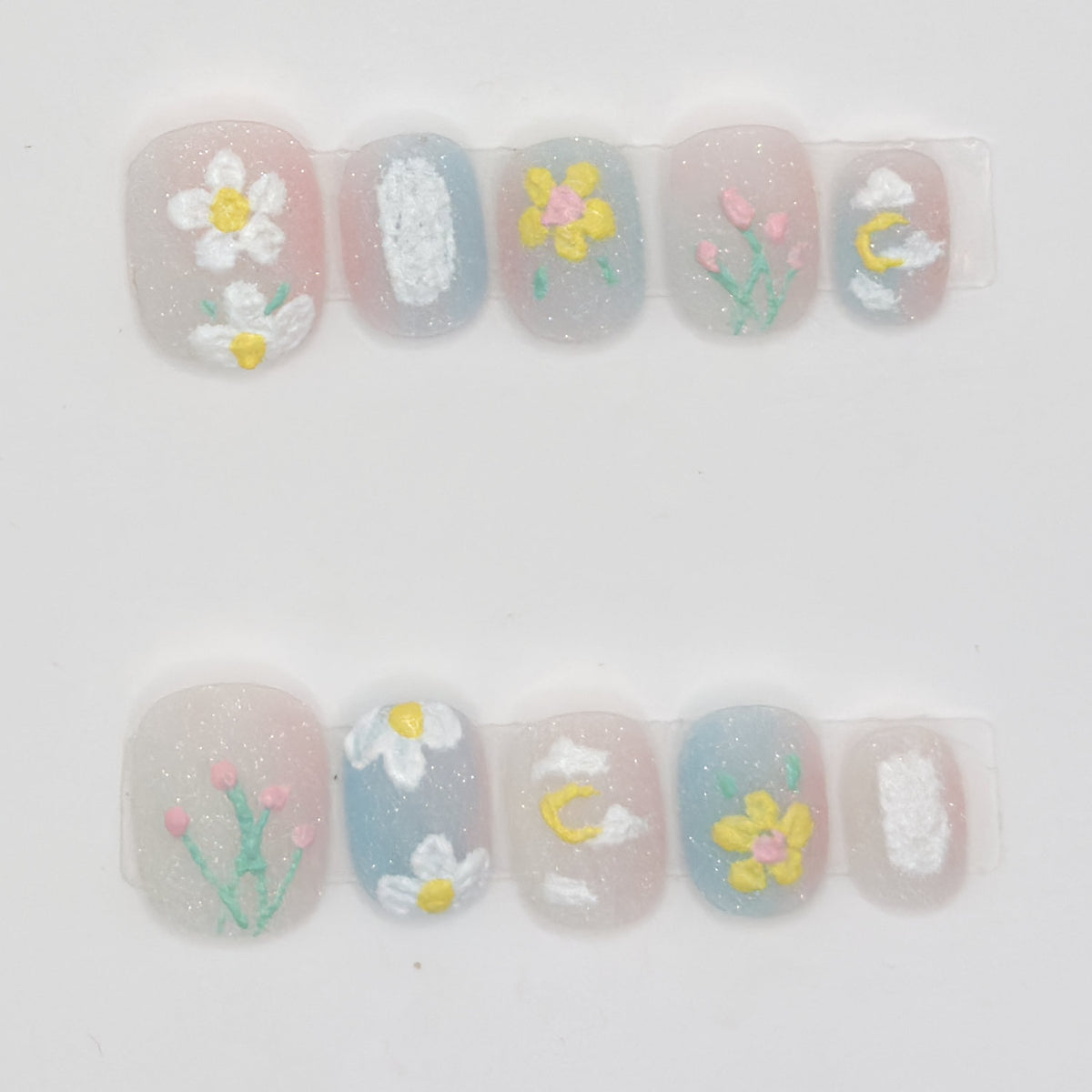 10 milky sheer press-ons in two rows with white daisies, pink tulips, a yellow flower, and a moon