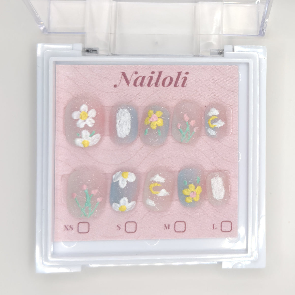 Daisy and tulip set on its backing card inside the open clear Nailoli case