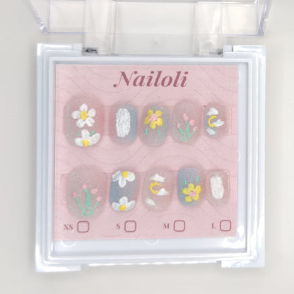 Daisy and tulip set on its backing card inside the open clear Nailoli case