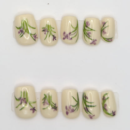 Close-up of 10 ivory square press-ons in two rows with purple lavender and green stem art