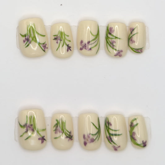 Close-up of 10 ivory square press-ons in two rows with purple lavender and green stem art