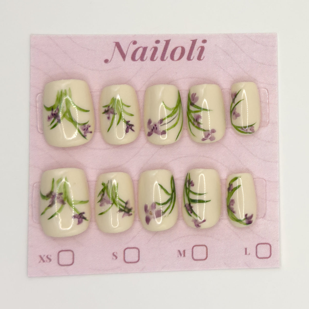 Ivory botanical nails on the pink Nailoli backing card with XS, S, M, and L size boxes