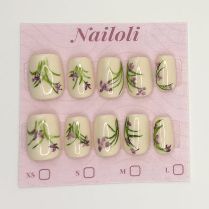 Ivory botanical nails on the pink Nailoli backing card with XS, S, M, and L size boxes