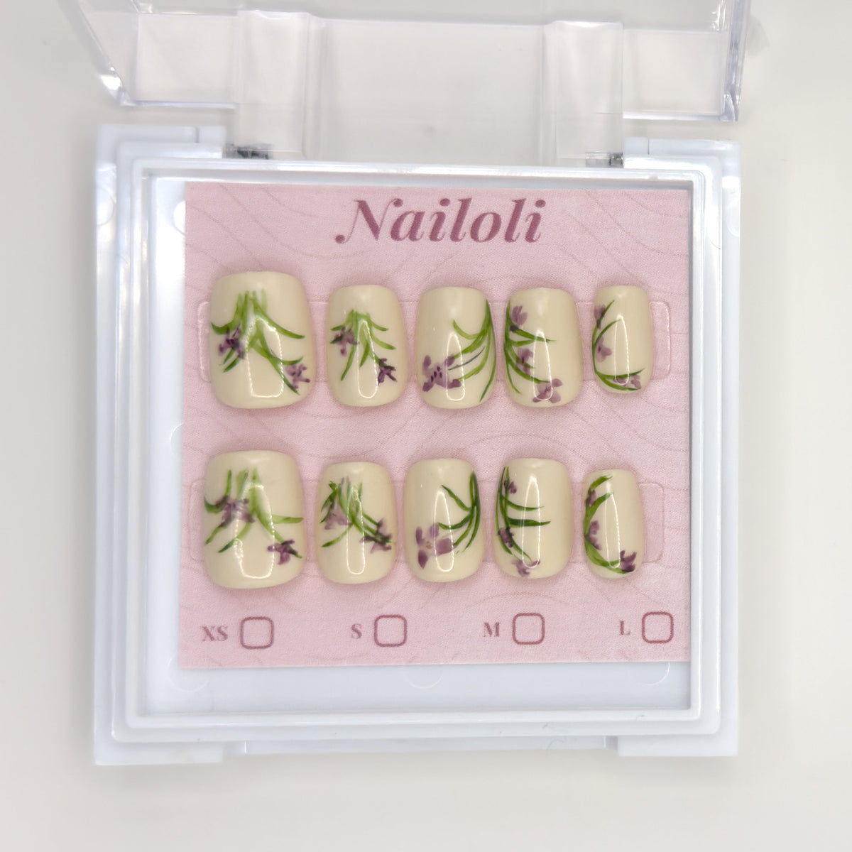 Ivory botanical set on its backing card inside the open clear Nailoli case