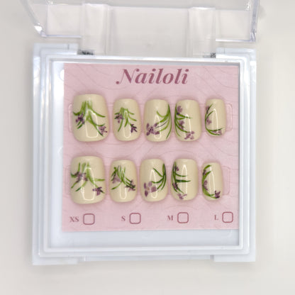 Ivory botanical set on its backing card inside the open clear Nailoli case