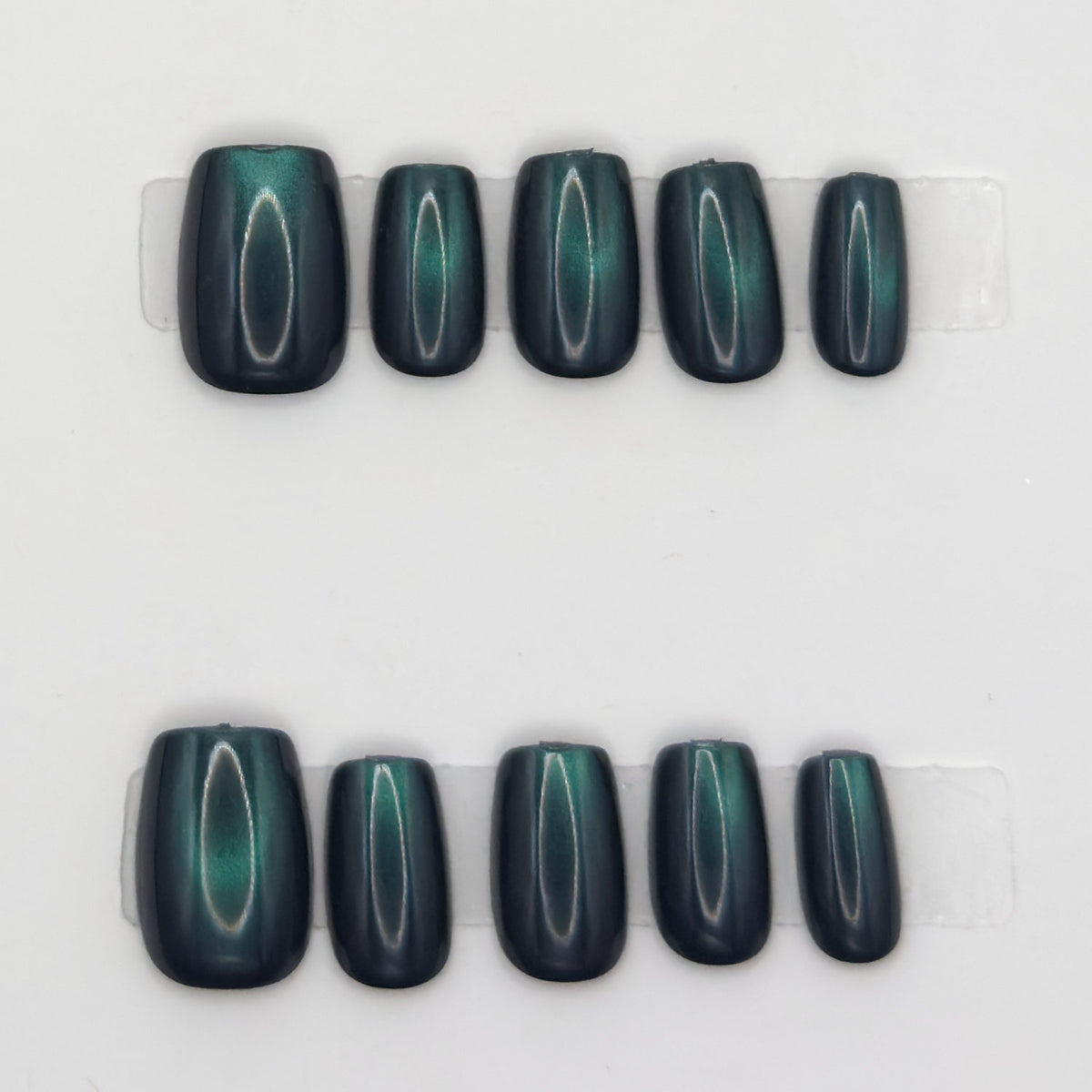 10 emerald cat eye square press-ons in two rows showing the green light band on each nail