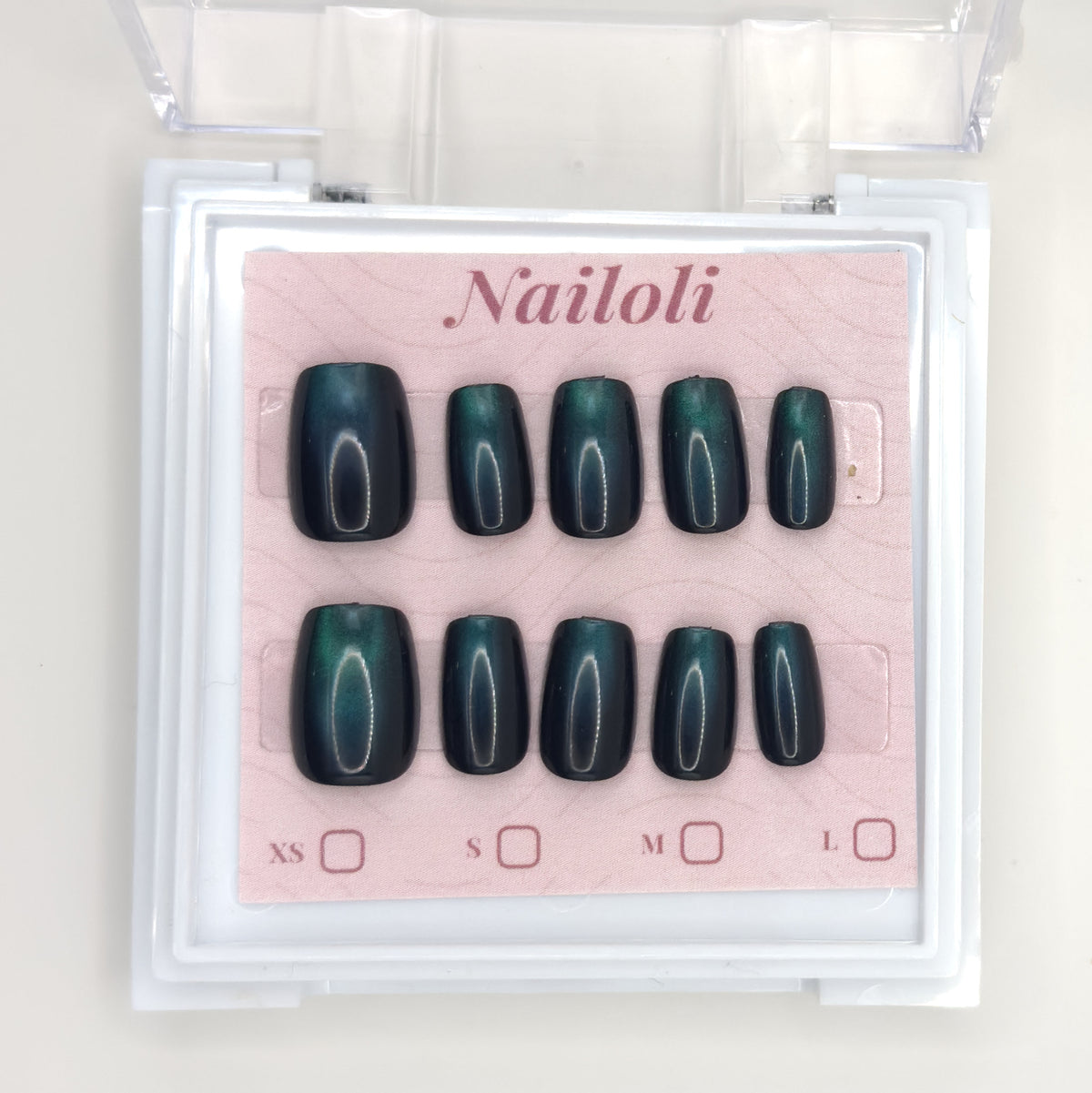 Emerald cat eye set on its backing card inside the open clear Nailoli case