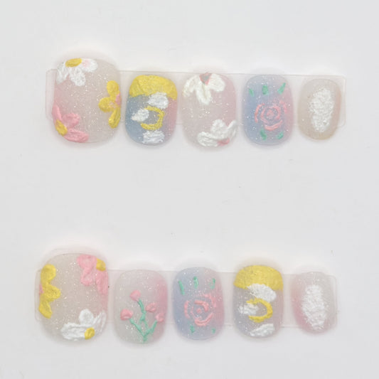 10 milky pastel press-ons in two rows with textured white daisies, pink roses, a moon, and sparkle
