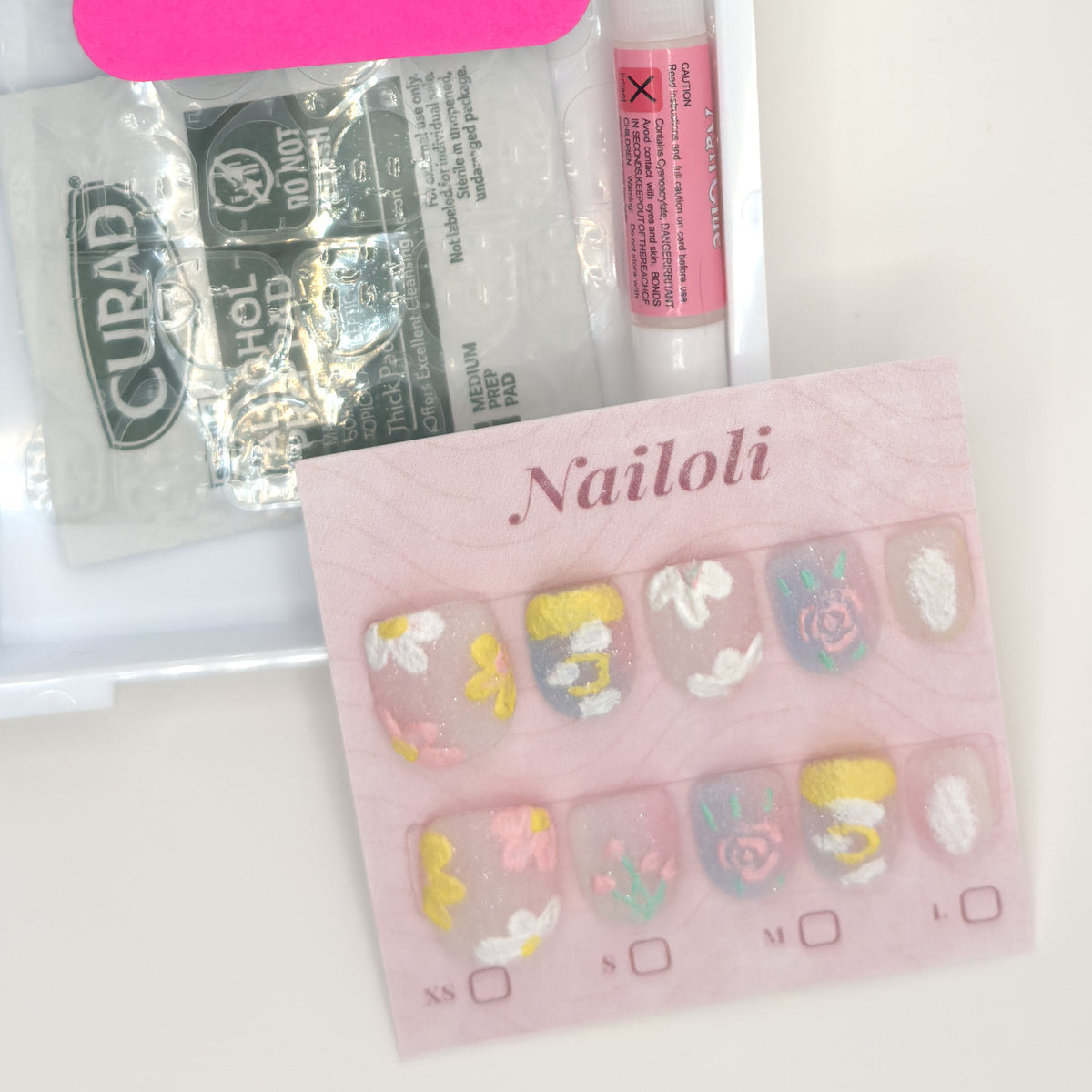 Milky pastel set on its card beside the open kit with nail glue, prep pad, and nail file