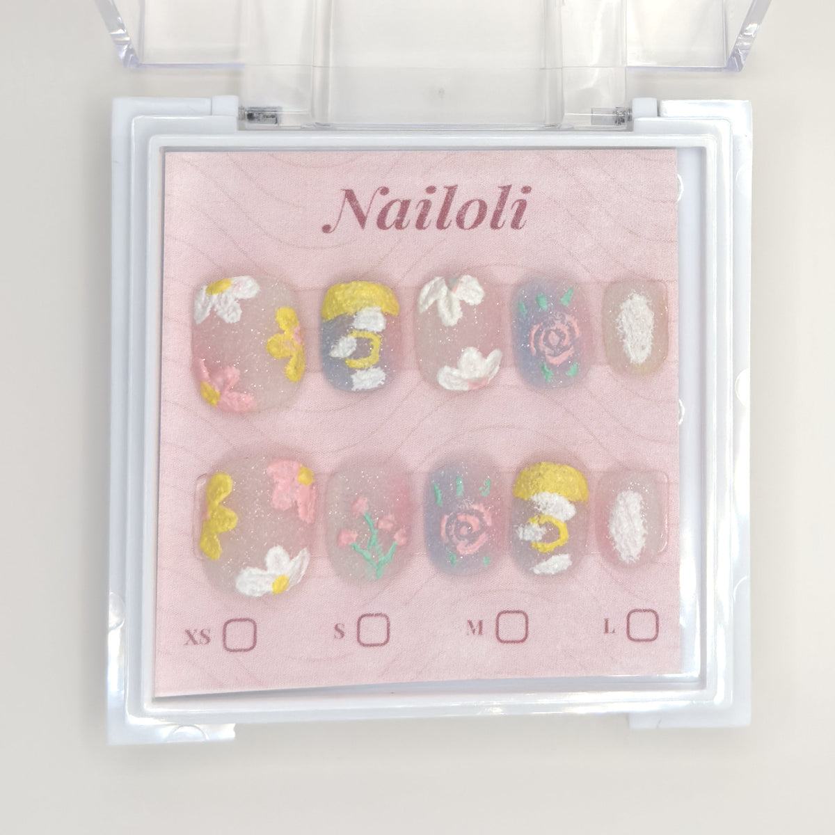 Milky pastel set on its backing card inside the open clear Nailoli case