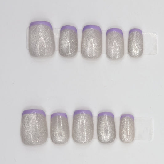 Close-up of 10 silver holographic square press-ons in two rows with thin lavender French tips