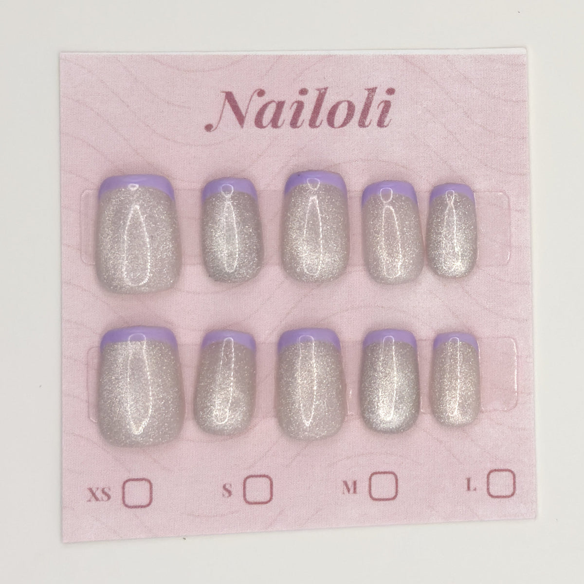 Silver holographic nails on the pink Nailoli backing card with XS, S, M, and L size boxes