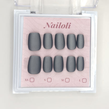 Matte charcoal set on its backing card inside the open clear Nailoli case
