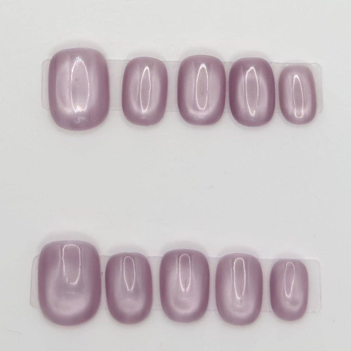 Close-up of 10 dusty mauve square press-ons in two rows on a light background