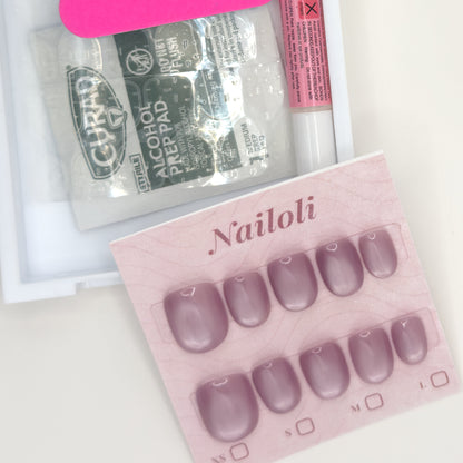 Dusty mauve set on its backing card beside the open kit with alcohol prep pad and nail glue