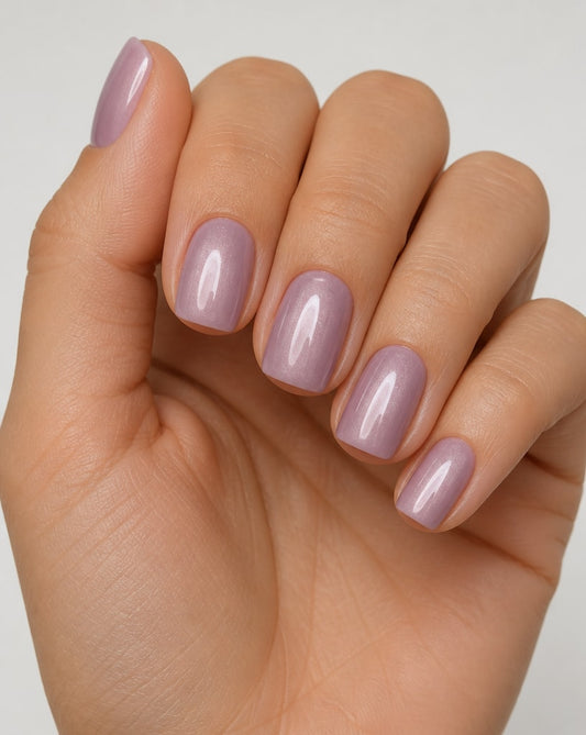 Hand wearing dusty mauve square press-on nails with a glossy finish