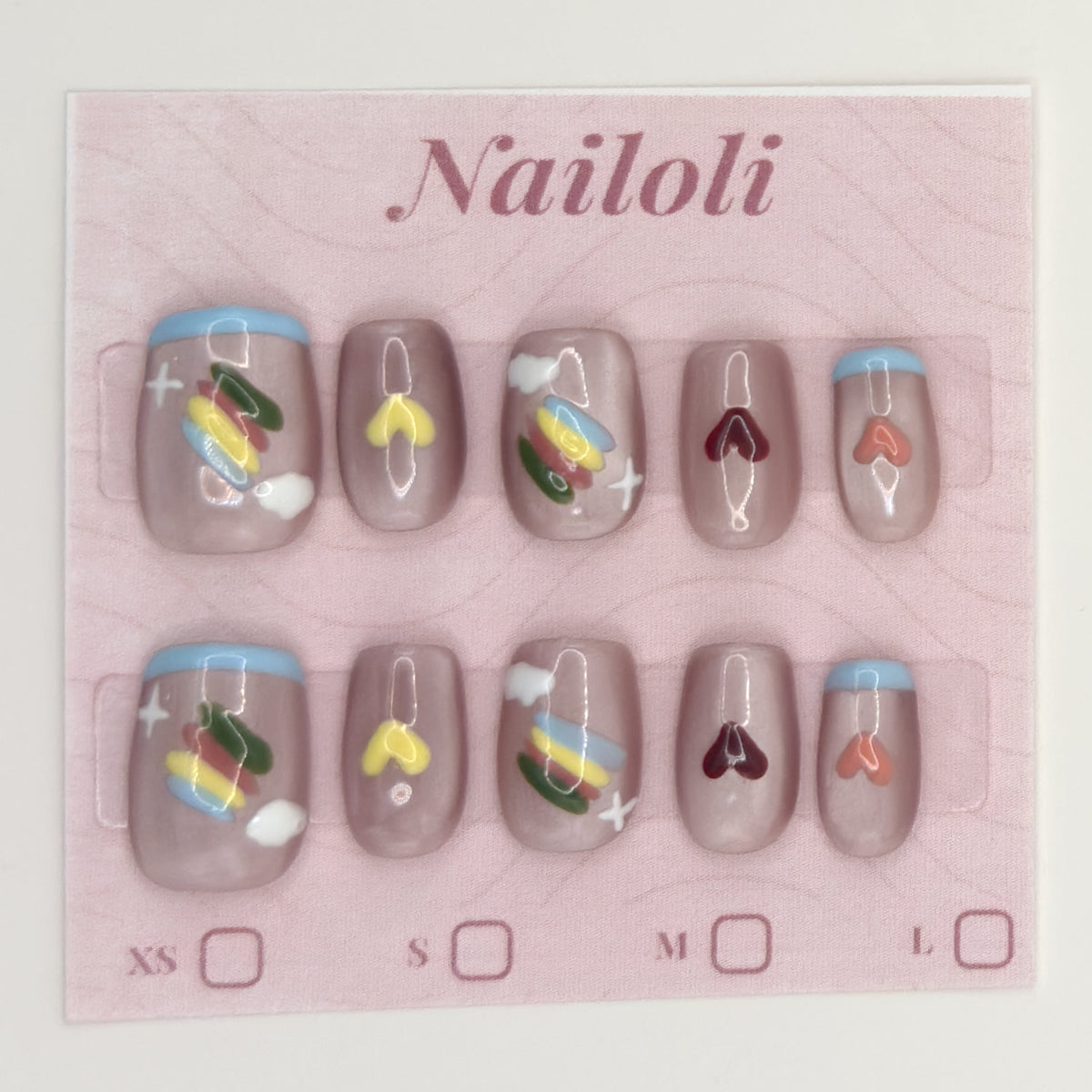 Taupe heart nails on the pink Nailoli backing card with XS, S, M, and L size boxes