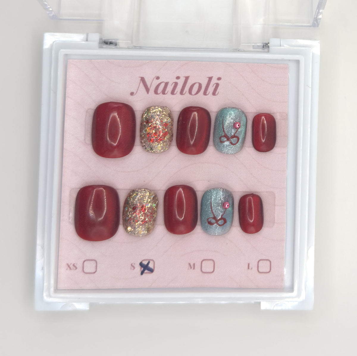 Burgundy glitter set on the Nailoli backing card with size S marked, inside the open clear case