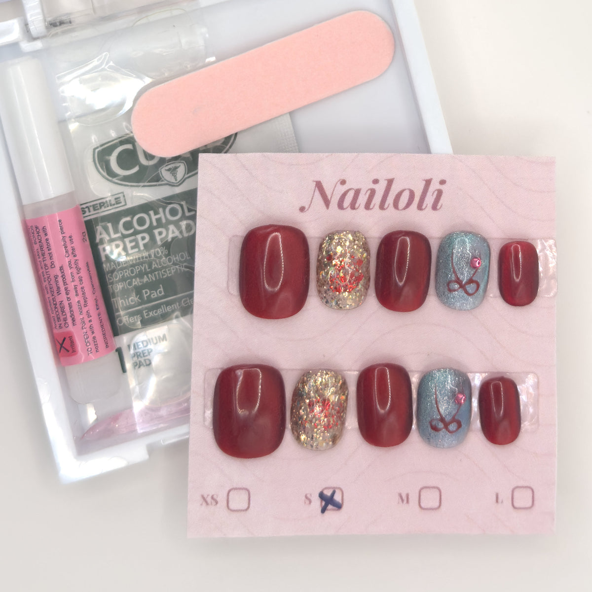 Burgundy glitter set on its card beside the open kit with nail glue, prep pad, and nail file