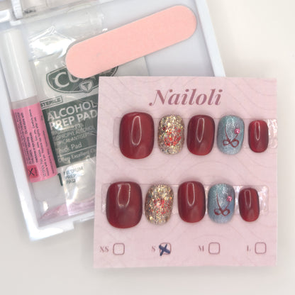 Burgundy glitter set on its card beside the open kit with nail glue, prep pad, and nail file
