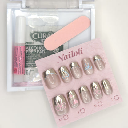 Champagne chrome set on its card beside the open kit with nail glue, prep pad, and nail file