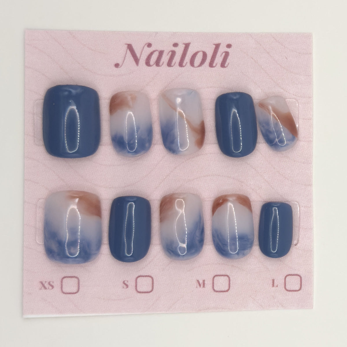 Ocean marble nails on the pink Nailoli backing card with XS, S, M, and L size boxes