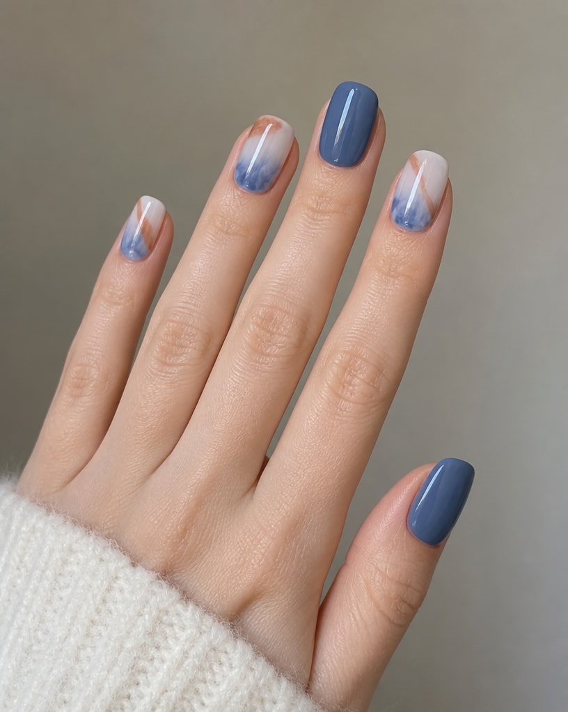 Hand wearing ocean marble square press-ons, slate blue and white nails marbled in blue and copper