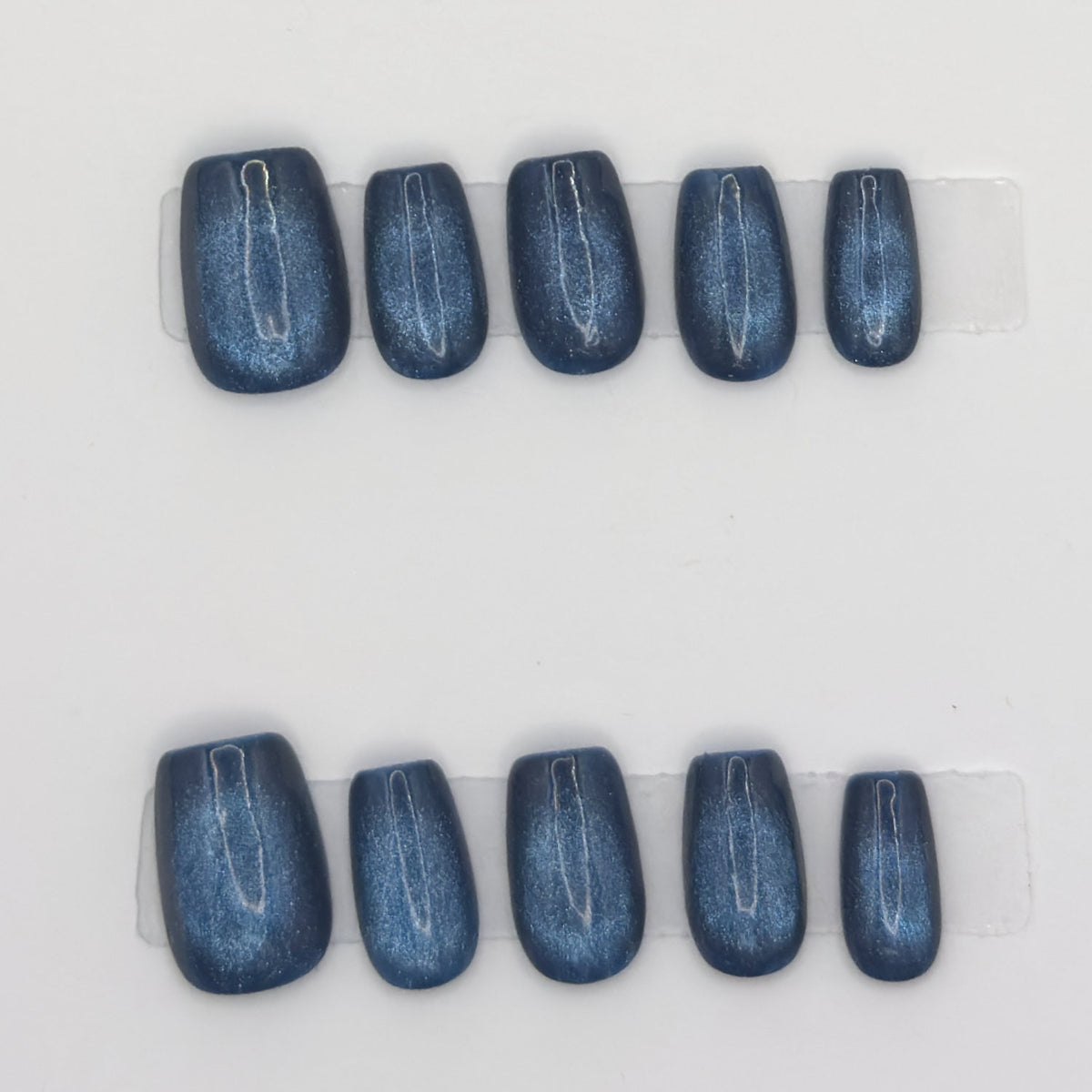 10 midnight cat eye square press-ons in two rows, showing the magnetic chrome line on each nail